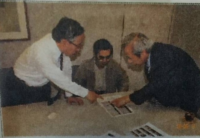 菅家利和さんの兄の秀典さん（中央）に血液採取の手順を説明する佐藤博史弁護士（左）と日本大学の押田茂實教授（右）